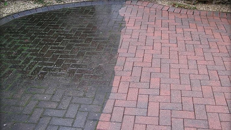 Before and after comparison of paver cleaning showing dark wet pavers on left and clean pink pavers on right